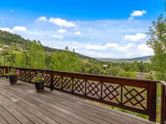 Enjoy breathtaking mountain views from this expansive wooden deck, perfect for entertaining or quiet relaxation.