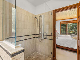 Experience luxury in this spacious bathroom featuring a modern glass-enclosed shower with a multi-head system.