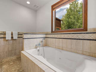 Indulge in relaxation in this luxurious bathroom featuring a spacious jetted tub, perfect for unwinding after a long day.