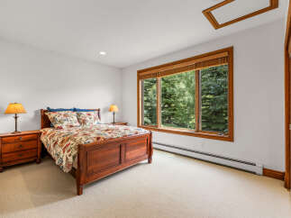 This charming bedroom features a beautiful wooden sleigh bed adorned with a floral comforter and matching pillows.