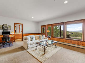 Experience breathtaking mountain views from this spacious living area, featuring a comfortable sofa and a glass-top coffee table perfect for gatherings.