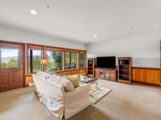 Experience breathtaking mountain views from this cozy living room, featuring a large sectional sofa perfect for relaxing.