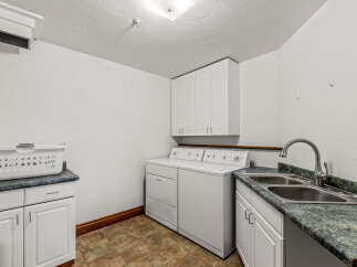 This laundry room features a white washer and dryer set, perfect for handling your household chores.