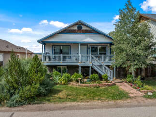 Charming home featuring a welcoming front porch with a grill and seating area, perfect for outdoor relaxation.