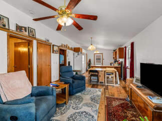 Step into this inviting living space featuring comfortable blue recliners and a charming dining area perfect for intimate meals.