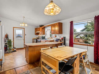 This charming kitchen and dining area features warm wooden cabinetry and a spacious breakfast bar, perfect for casual meals and entertaining.
