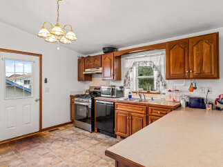 This charming kitchen features warm wooden cabinetry and a functional layout perfect for everyday living.