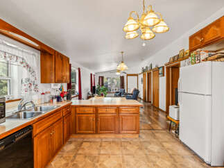 Discover this charming kitchen featuring warm wooden cabinetry and a spacious island, perfect for meal preparation and casual dining.