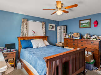 This cozy bedroom features a comfortable bed with blue bedding and a wooden headboard, perfect for relaxation.