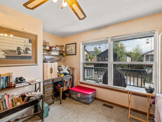 This versatile room offers a dedicated workspace with a classic wooden desk and ample shelving for books and storage.