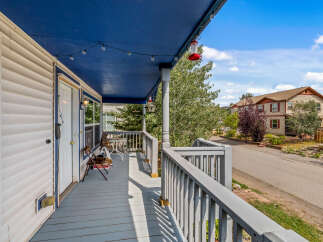 Enjoy the outdoors from this charming covered porch, perfect for relaxing with a cup of coffee or entertaining guests.