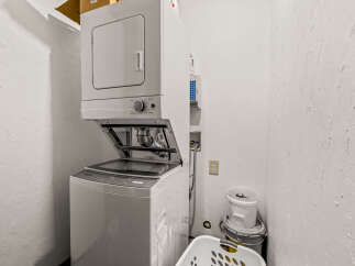 Discover convenience in this laundry space featuring a stacked washer and dryer unit, perfect for maximizing space.