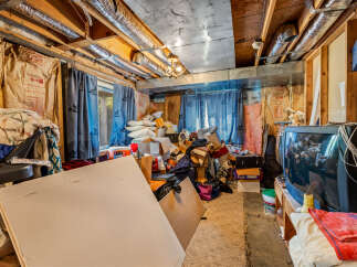 This unfinished basement offers a blank canvas for your creative vision, featuring exposed joists and insulation ready for customization.
