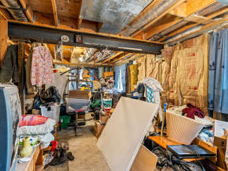 This cluttered basement space offers potential for customization and storage.