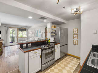 Discover this charming kitchen featuring stainless steel appliances, a sleek stovetop, and ample cabinet space.