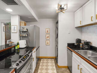 Discover this charming kitchen featuring a sleek electric stovetop and a modern air fryer, perfect for culinary adventures.