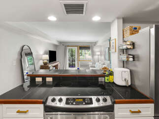 Discover this charming kitchen featuring a sleek black granite countertop with an integrated stovetop, perfect for culinary adventures.