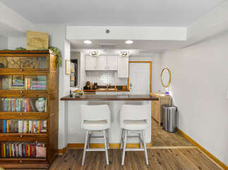 This charming kitchen and dining area features a sleek breakfast bar with two comfortable stools, perfect for casual meals or entertaining guests.