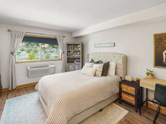 Discover comfort and style in this inviting bedroom, featuring a plush tufted headboard and a charming gingham comforter.