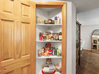 Discover ample storage in this home's charming pantry, featuring well-organized shelves stocked with a variety of pantry staples.