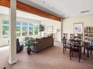 Enjoy breathtaking mountain views from this spacious living area, featuring a comfortable sofa and recliner perfect for relaxation.