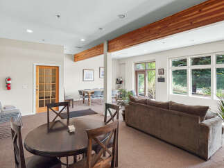 This spacious common area features a large dining table with chairs, perfect for gatherings, and a comfortable sectional sofa ideal for relaxation.