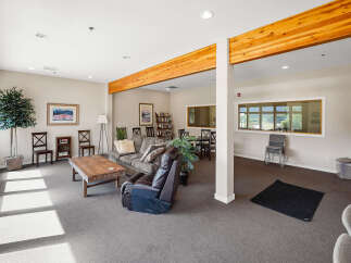 This spacious common area features comfortable seating, including a plush sofa and a recliner, perfect for relaxation.