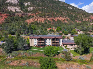 Discover this stunning multi-story apartment complex nestled against a majestic mountain backdrop.