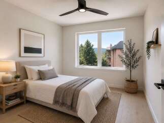 Experience comfort and style in this beautifully appointed bedroom, featuring a plush bed, a modern ceiling fan, and a large window offering scenic views.