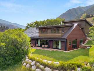 Experience modern mountain living in this stunning home, featuring expansive windows that frame breathtaking views of the surrounding hills.