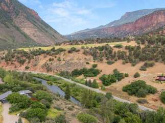 Discover this stunning property nestled in a picturesque valley, offering breathtaking mountain views and a serene riverfront setting.