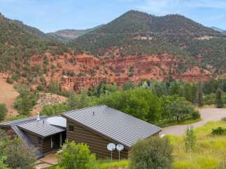 Nestled amidst stunning red rock formations and lush greenery, this modern home offers a unique architectural design.
