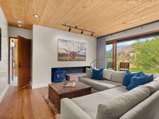 Experience rustic charm and modern comfort in this inviting living room, featuring a cozy blue wood-burning stove set against a brick fireplace.