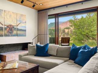 Experience breathtaking mountain views from this stunning living room, featuring a large sectional sofa perfect for relaxation.