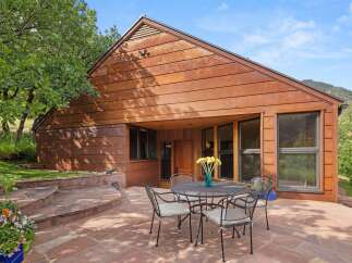 Experience modern living with this stunning home featuring a unique rusted metal exterior and expansive windows that invite natural light.