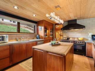 Experience culinary excellence in this stunning kitchen, featuring rich wood cabinetry and a spacious butcher block island perfect for meal prep.