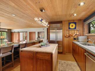 Experience luxury in this stunning kitchen featuring warm wood cabinetry and a spacious island perfect for entertaining.