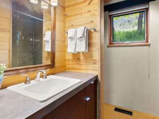 This bathroom features a modern vanity with a sleek countertop and a double-handle faucet, complemented by plush white towels neatly hung on a chrome rack.