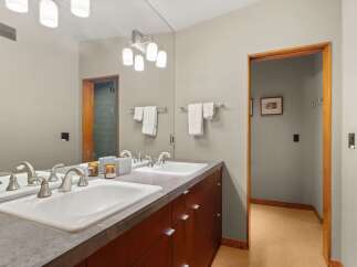 This modern bathroom features a spacious double vanity with sleek silver faucets and ample counter space.