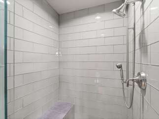 Step into this modern shower featuring sleek, light gray subway tiles that create a spa-like ambiance.