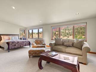 Experience breathtaking views from this spacious bedroom suite, featuring a comfortable king-size bed and a cozy seating area.