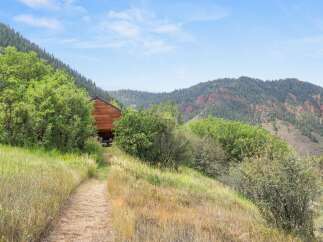 Discover this charming wooden cabin nestled amidst lush greenery and rolling hills.