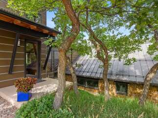 Discover this stunning modern home featuring a unique architectural design with a striking brown exterior and a sleek metal roof.