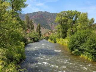 Experience the tranquility of this stunning riverfront property, offering breathtaking views of a pristine mountain landscape.