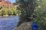 Escape to this serene riverside property, offering breathtaking views of red rock formations and a flowing river.