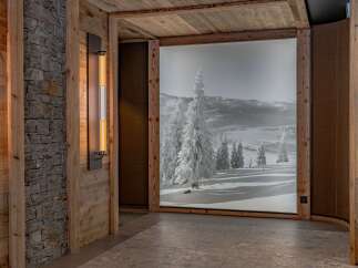 Experience the ultimate alpine retreat with this stunning interior featuring natural wood paneling and a captivating winter landscape mural.