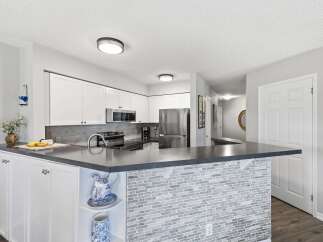 Discover this beautifully updated kitchen featuring sleek white cabinetry and a modern dark countertop.