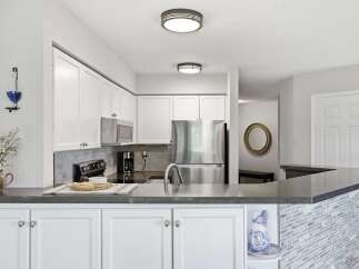 Discover this beautifully updated kitchen featuring sleek white cabinetry and modern stainless steel appliances.
