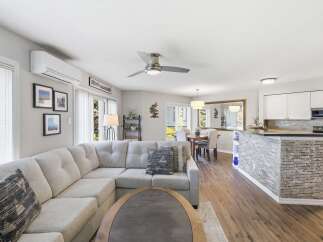 Experience modern living in this open-concept home featuring a spacious sectional sofa and a stylish dining area.