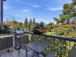Enjoy outdoor living on this charming balcony, complete with a grill for summer cookouts and a cozy seating area perfect for morning coffee.